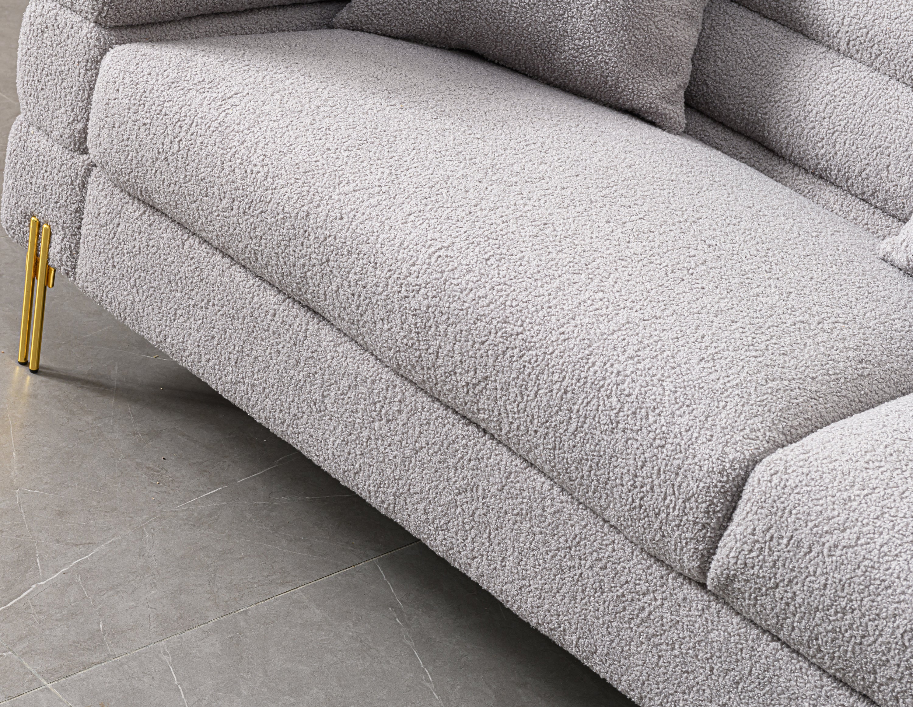 Luxurious and comfortable upholstered sofa with golden legs and pillows for living room and reception area