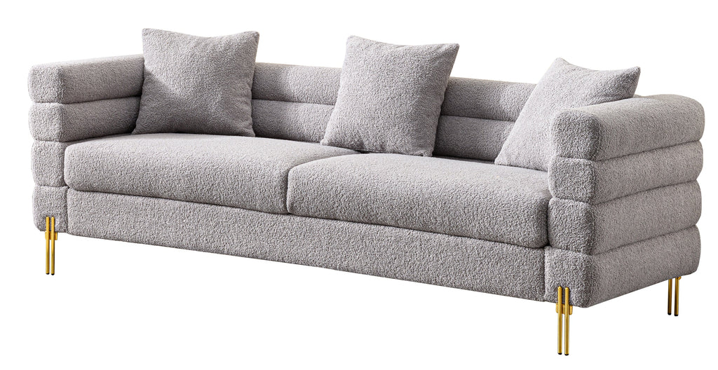 Luxurious and comfortable upholstered sofa with golden legs and pillows for living room and reception area