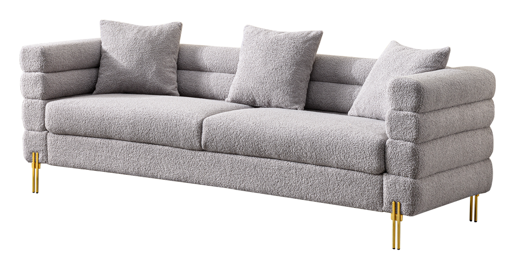 Luxurious and comfortable upholstered sofa with golden legs and pillows for living room and reception area