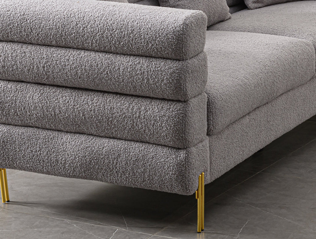 Luxurious and comfortable upholstered sofa with golden legs and pillows for living room and reception area