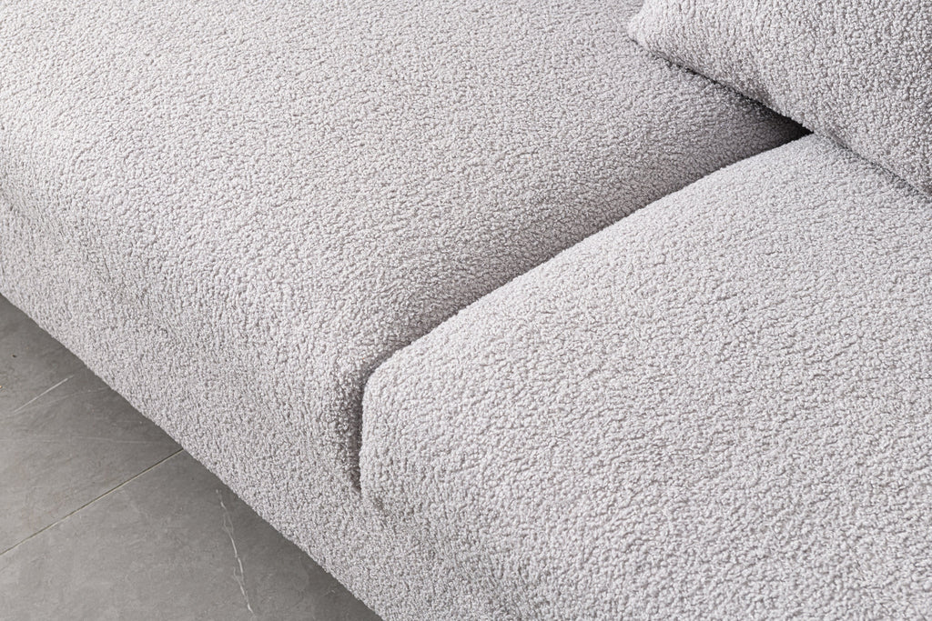 Luxurious and comfortable upholstered sofa with golden legs and pillows for living room and reception area