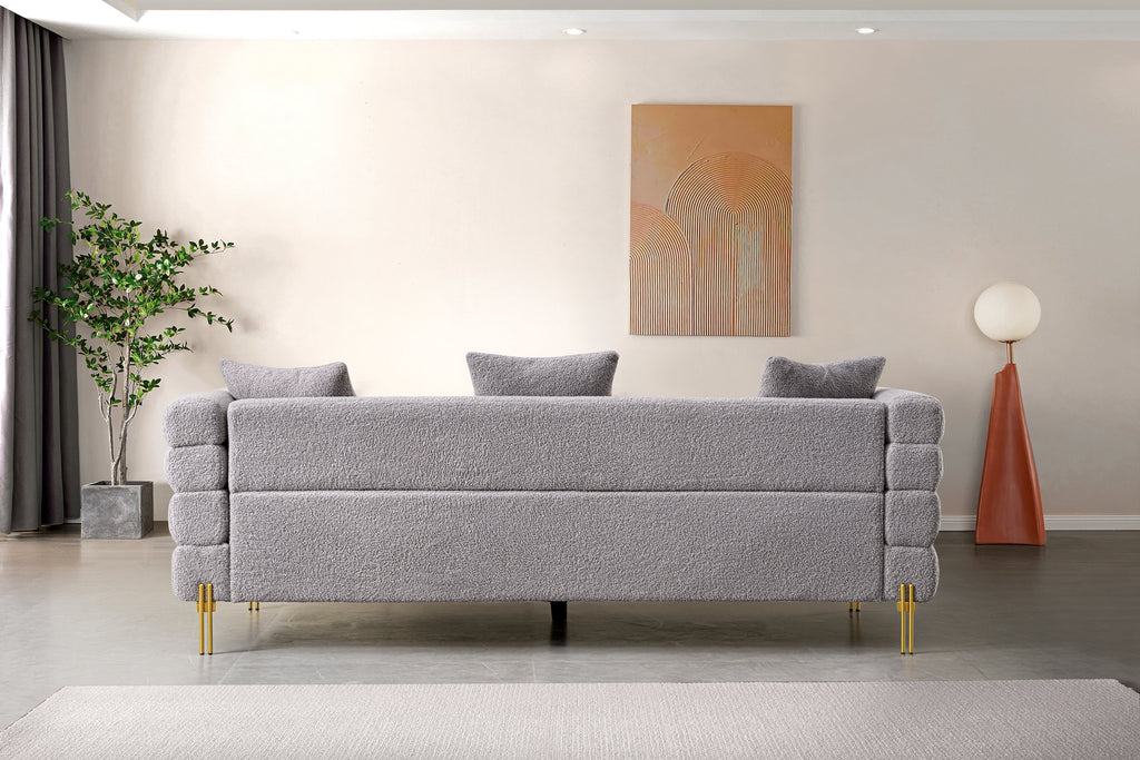 Luxurious and comfortable upholstered sofa with golden legs and pillows for living room and reception area