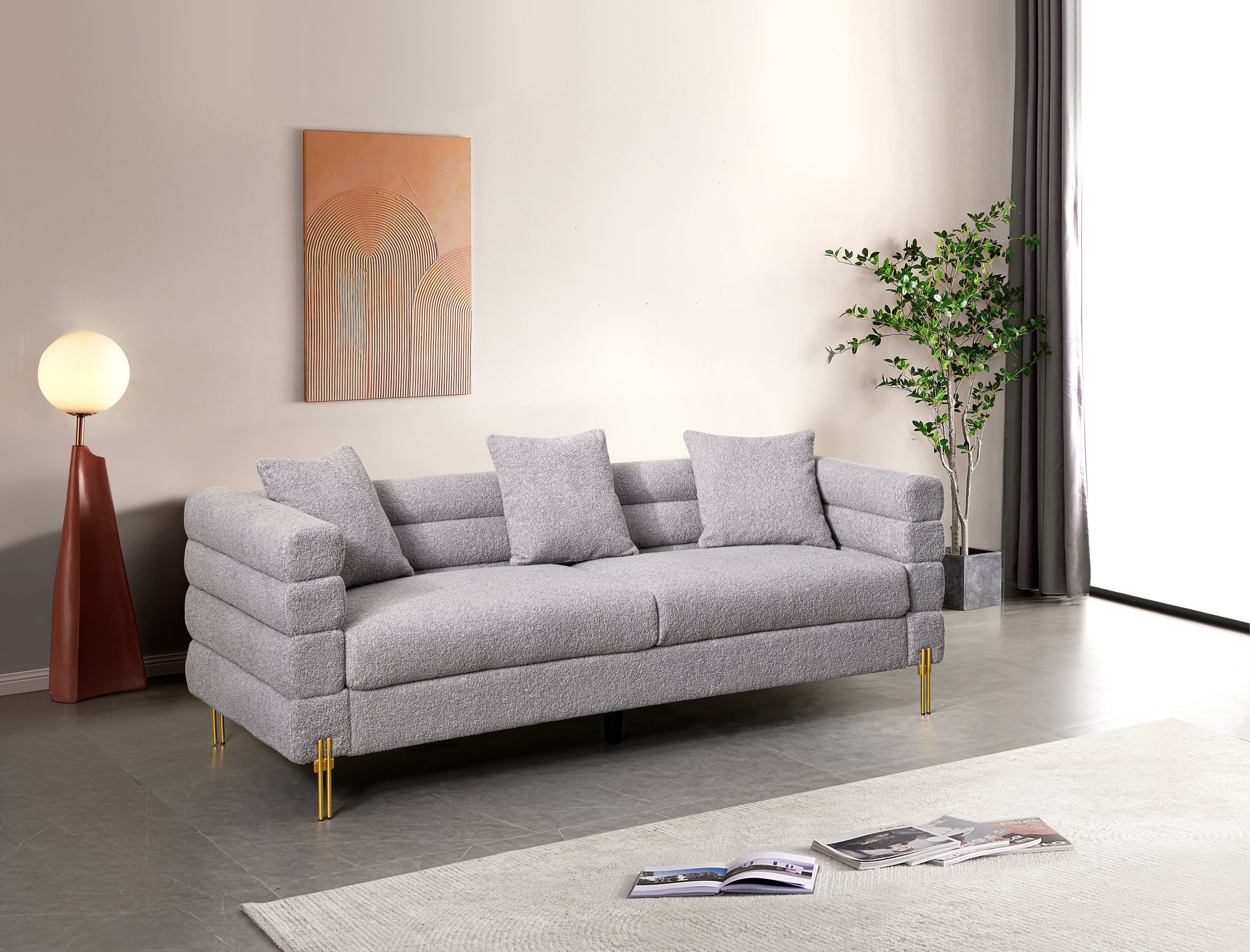 Luxurious and comfortable upholstered sofa with golden legs and pillows for living room and reception area
