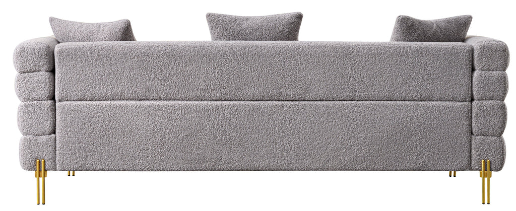 Luxurious and comfortable upholstered sofa with golden legs and pillows for living room and reception area